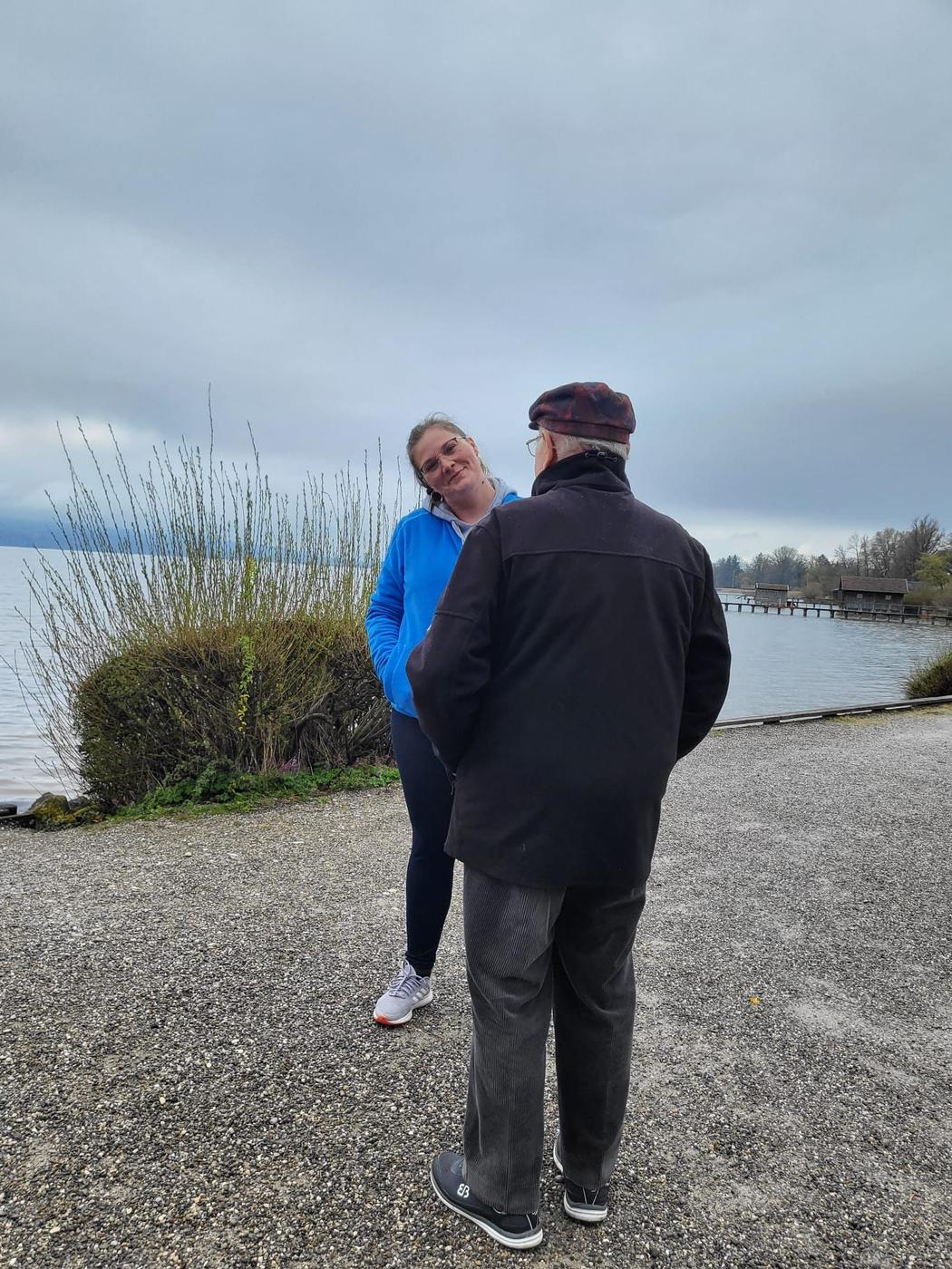 Pflegekraft von Pflegedienst Treib begleitet einen Senior bei einem Spaziergang am See