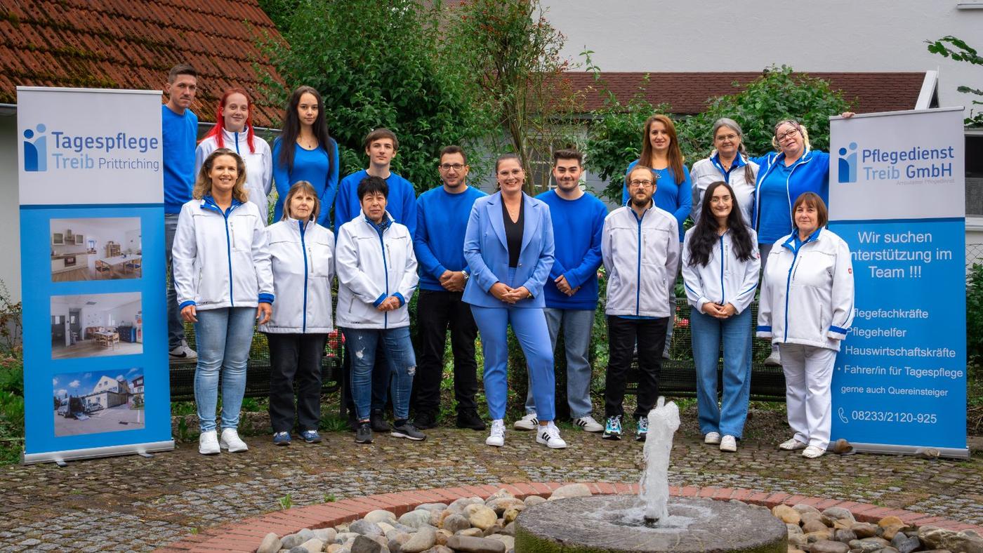 Team des Pflegedienstes Treib vor den Firmenbannern